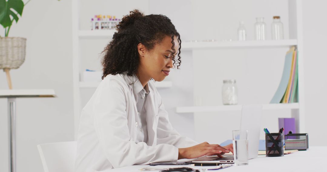 Image of portrait of smiling biracial female doctor using laptop - Free Images, Stock Photos and Pictures on Pikwizard.com