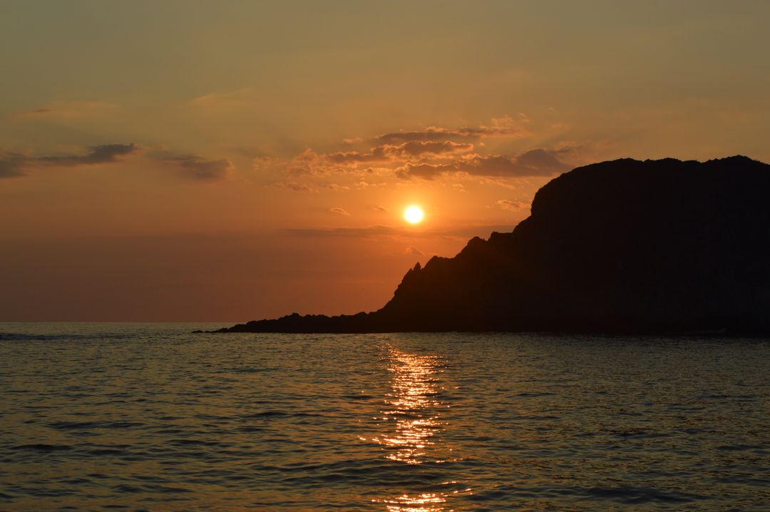 Golden Sunset Over Rocky Seashore Scenery with Reflecting Ocean - Free Images, Stock Photos and Pictures on Pikwizard.com