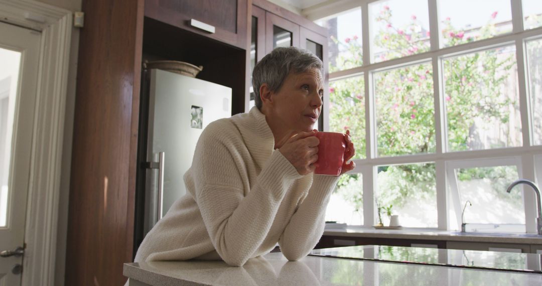 Woman Drinking Coffee in Modern Kitchen with Large Windows - Free Images, Stock Photos and Pictures on Pikwizard.com