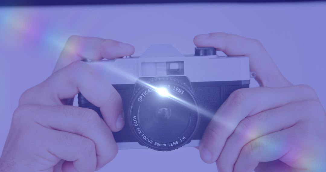 Hands Holding Vintage Camera with Lens Flare