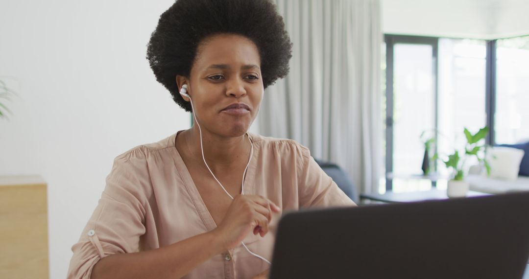 Smiling African American Woman with Afro Using Laptop at Home