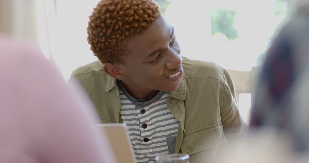 Young African-American Man Smiling and Listening Intently at Home - Free Images, Stock Photos and Pictures on Pikwizard.com