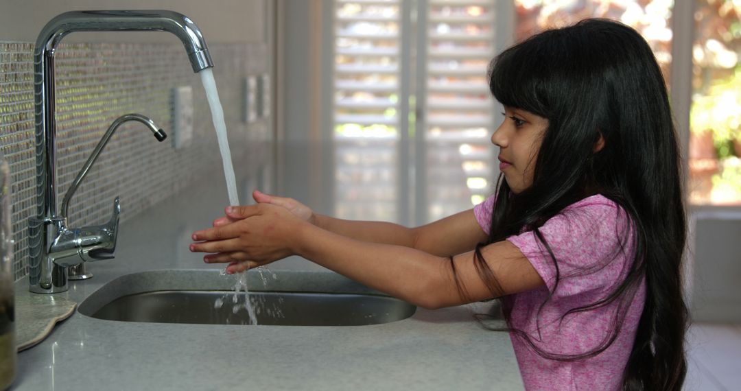 Young Girl Washing Hands Under Kitchen Faucet - Free Images, Stock Photos and Pictures on Pikwizard.com