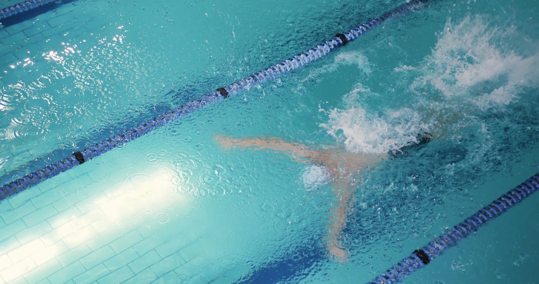 Competitive Swimmer Racing Through Clear Blue Indoor Pool - Free Images, Stock Photos and Pictures on Pikwizard.com