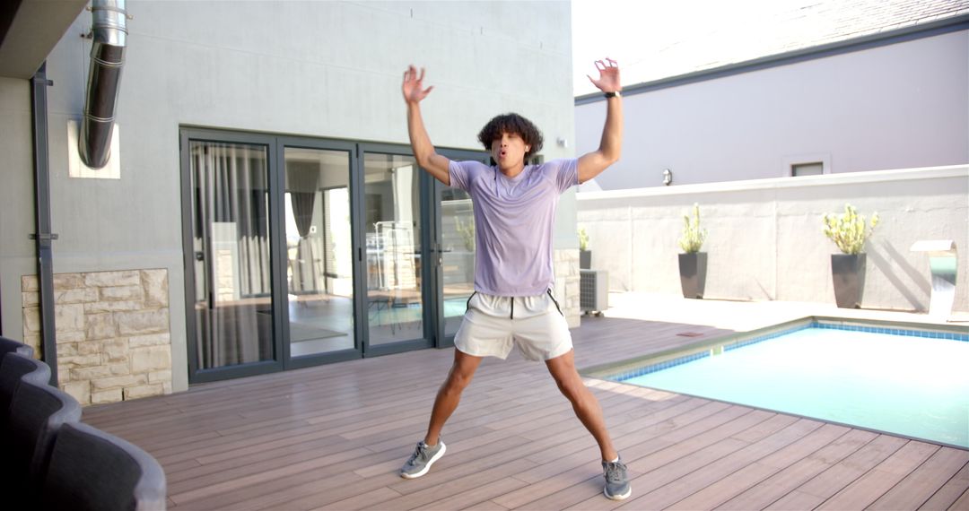 Energetic Man Performing Outdoor Jumping Jacks by Poolside