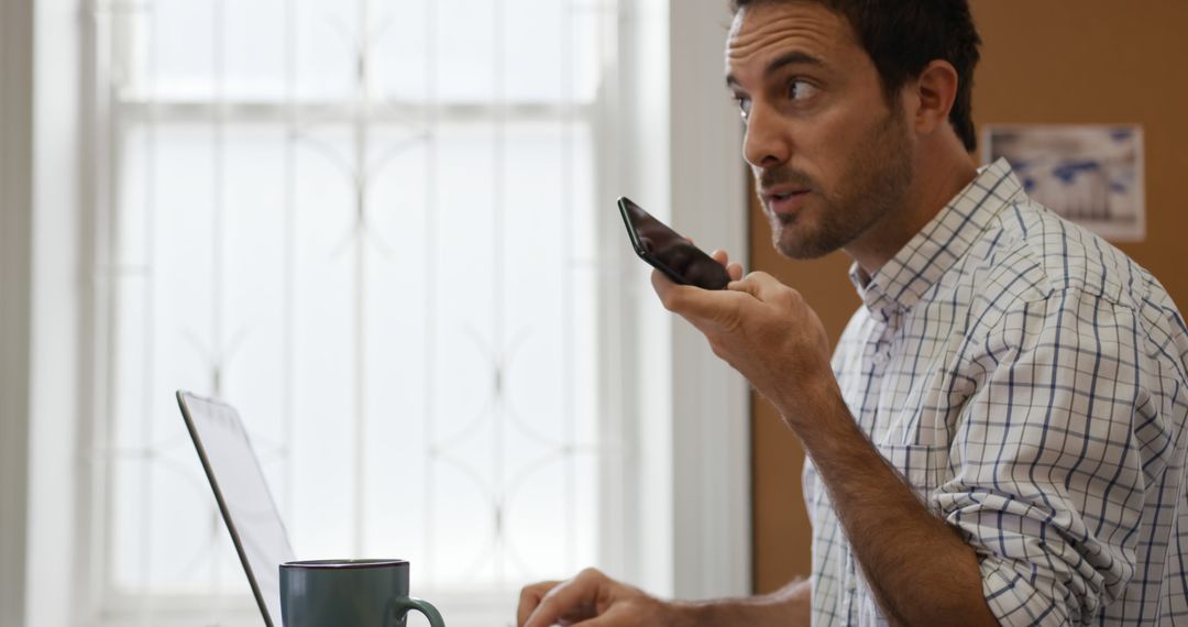 Young Professional Using Voice Commands on Smartphone While Working - Free Images, Stock Photos and Pictures on Pikwizard.com