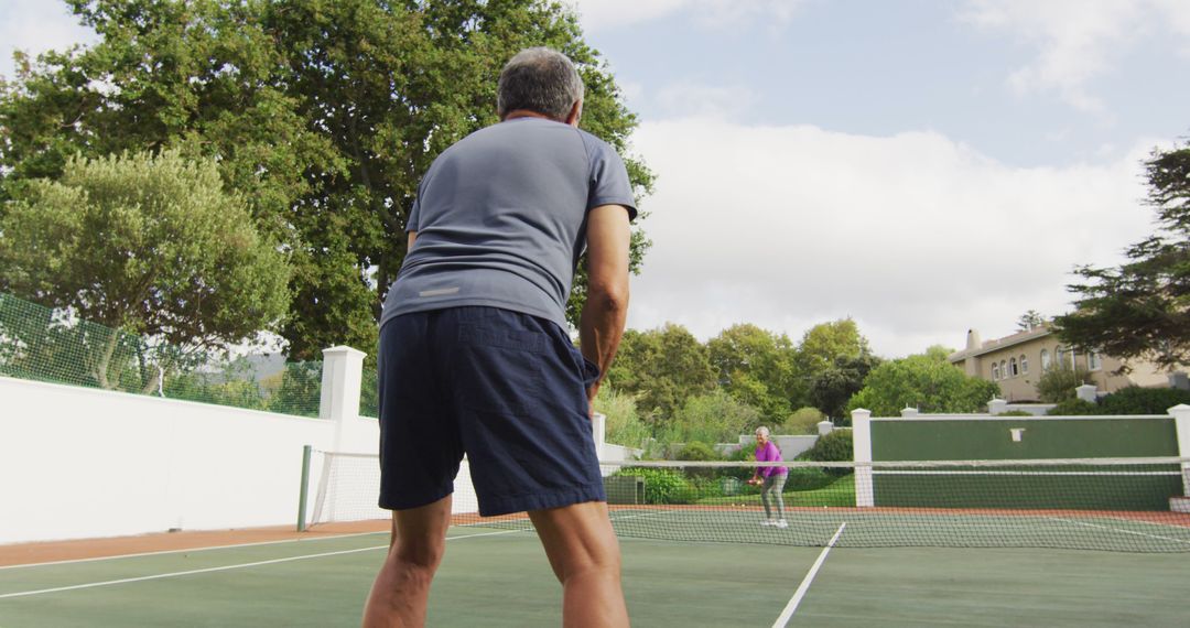 Mature Man Playing Outdoor Tennis Game on Sunny Day - Free Images, Stock Photos and Pictures on Pikwizard.com