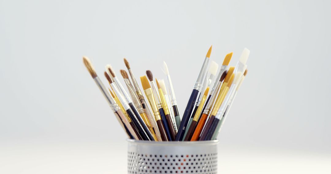 Assorted Paintbrushes in Metal Holder on White Background - Free Images, Stock Photos and Pictures on Pikwizard.com