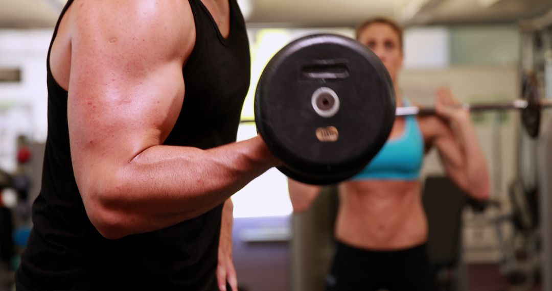 Man and Woman Exercising in a Gym with Weights - Free Images, Stock Photos and Pictures on Pikwizard.com