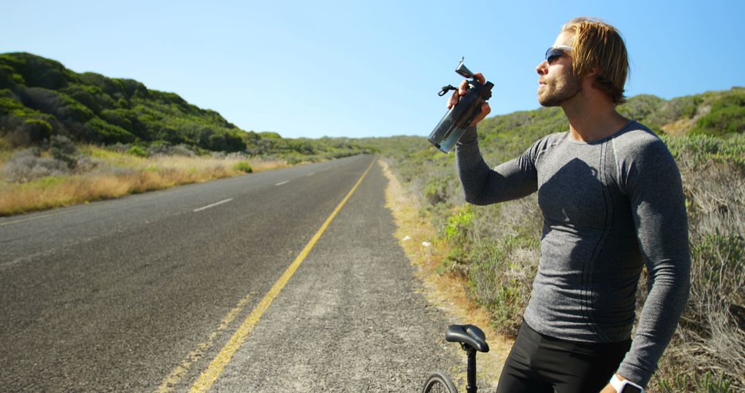 Cyclist Taking a Break for Hydration on Open Road - Free Images, Stock Photos and Pictures on Pikwizard.com