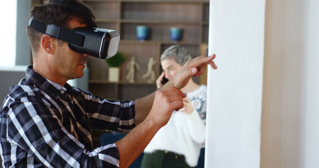 Man Using Virtual Reality Headset Interacting with Digital Content Indoors - Free Images, Stock Photos and Pictures on Pikwizard.com