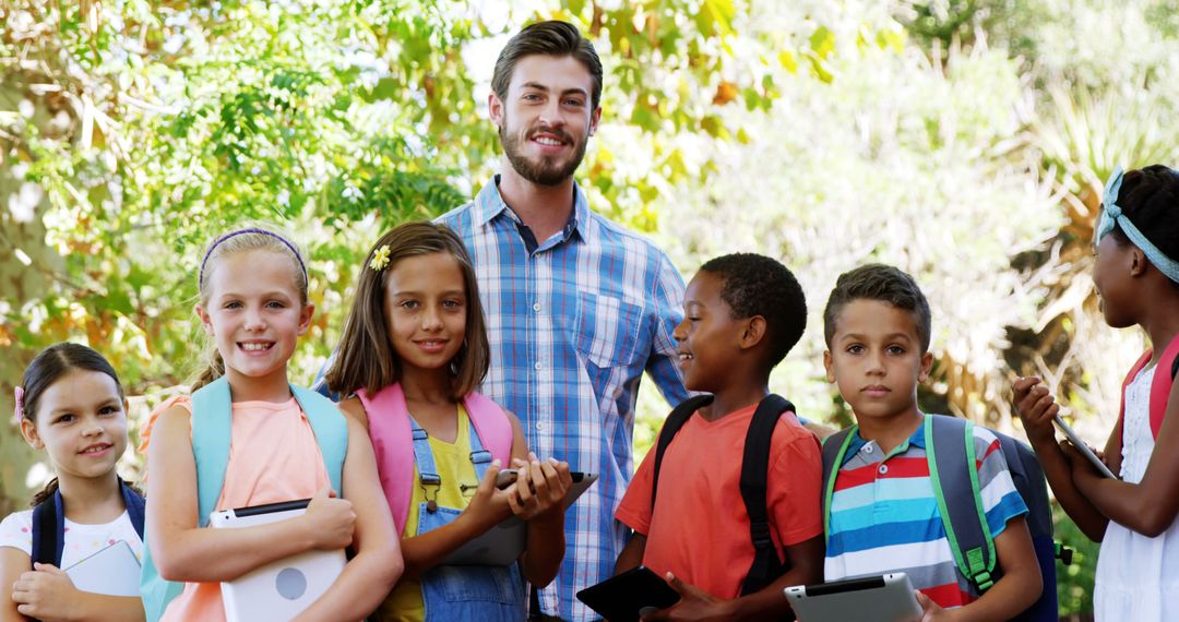 Smiling Teacher and Diverse Group of Students Outdoors Holding Tablets - Free Images, Stock Photos and Pictures on Pikwizard.com