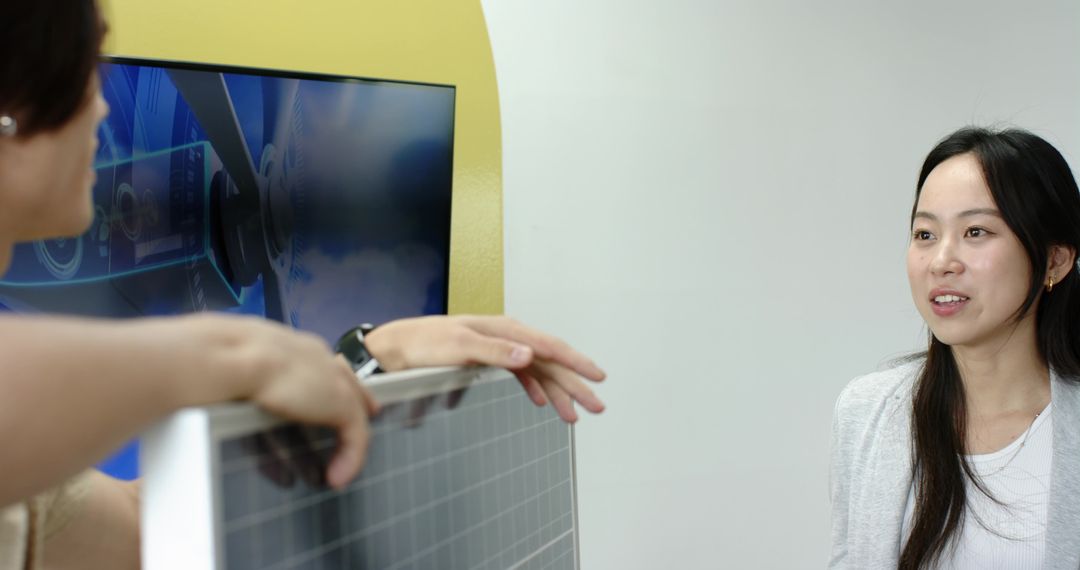 Diverse Team Discussing Solar Panel Innovation Near Futuristic Display