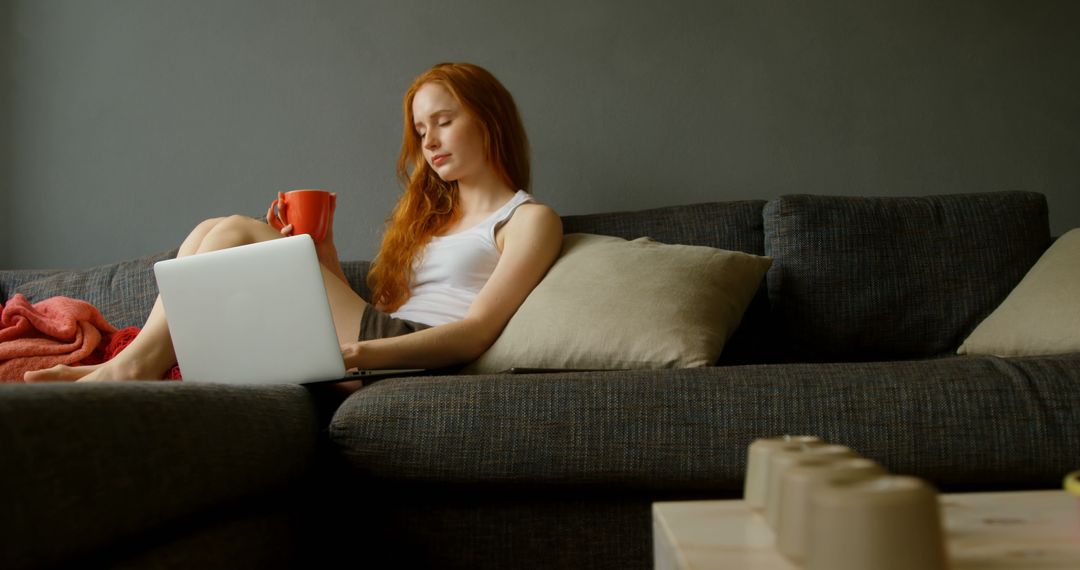 Woman Relaxing on Couch with Coffee and Laptop - Free Images, Stock Photos and Pictures on Pikwizard.com