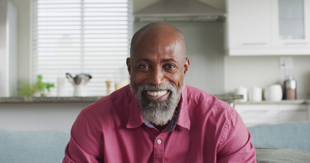 Smiling African American Man Sitting in Contemporary Kitchen - Free Images, Stock Photos and Pictures on Pikwizard.com