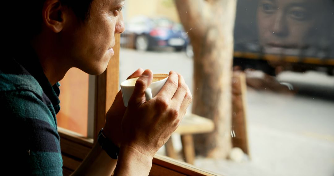 Man drinking coffee while looking out of window in cafe - Free Images, Stock Photos and Pictures on Pikwizard.com