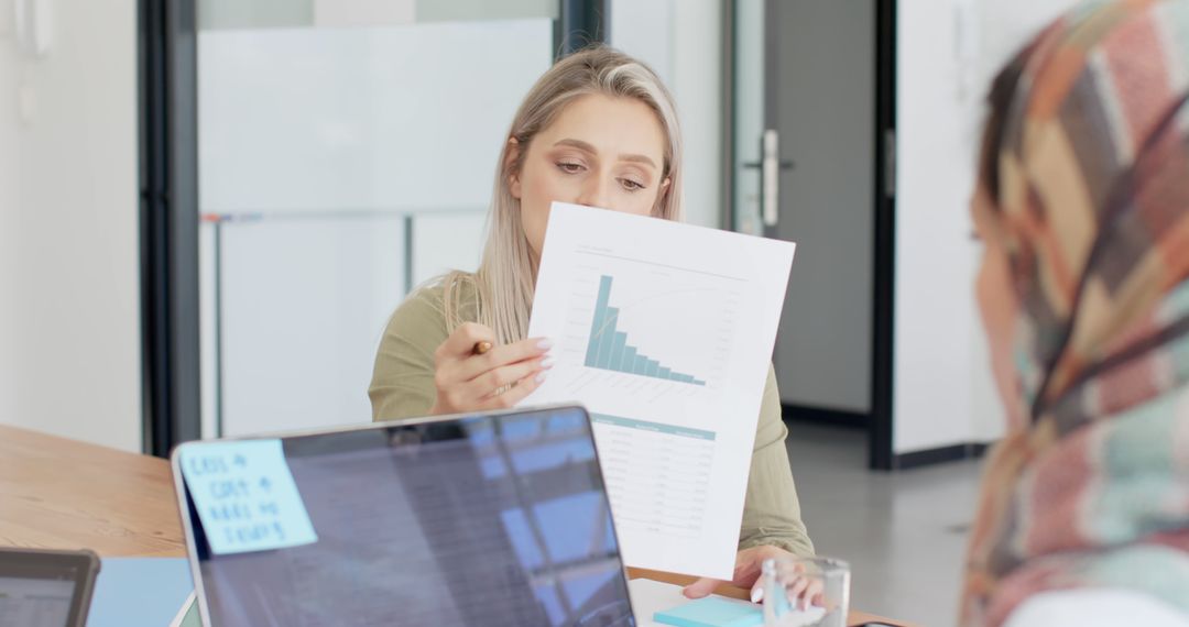 Businesswomen Analyzing Financial Chart During Team Meeting - Free Images, Stock Photos and Pictures on Pikwizard.com