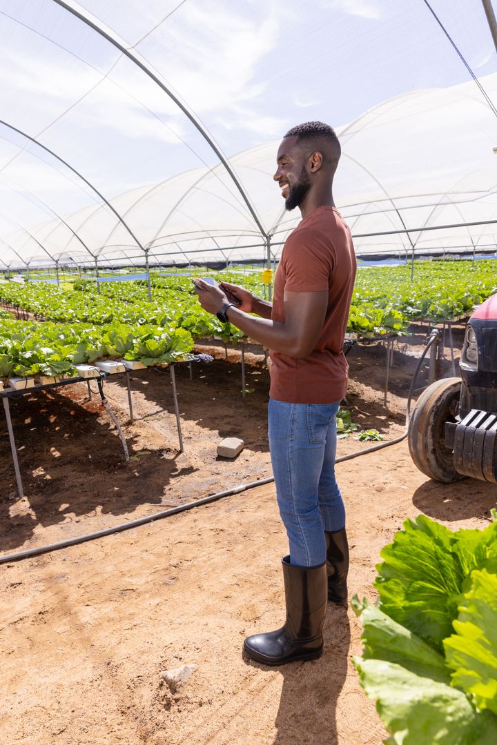 Agricultural Professional Using Smartphone in Modern Greenhouse