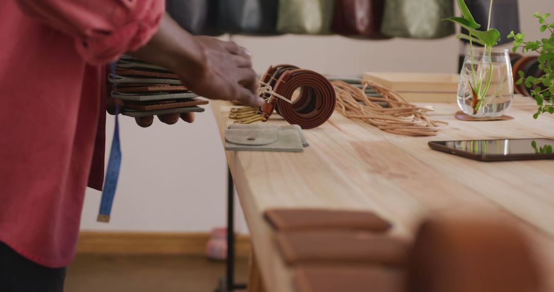 Craftsman Arranging Wallets in Artisan Leather Workshop