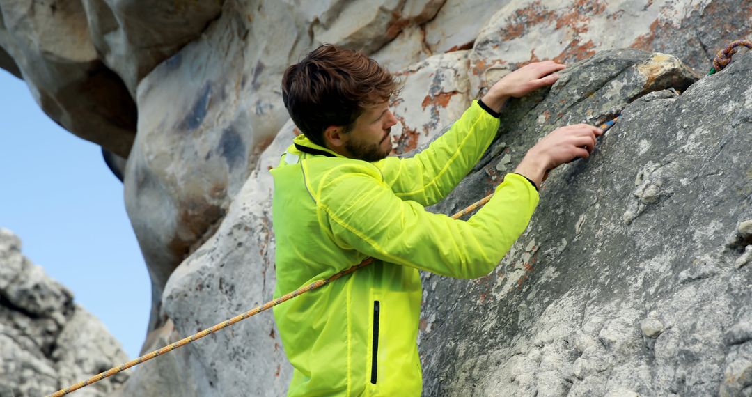 Rock Climber in Bright Green Jacket Ascending Cliff - Free Images, Stock Photos and Pictures on Pikwizard.com