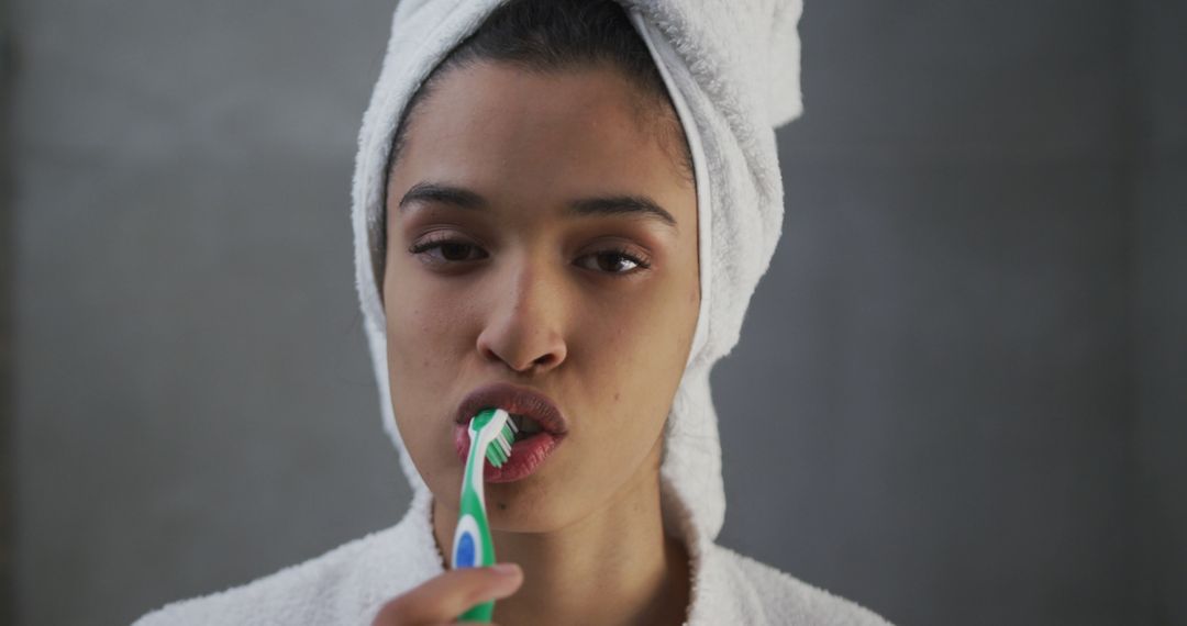 Woman Brushing Teeth with Toothbrush Wrapped in Towel - Free Images, Stock Photos and Pictures on Pikwizard.com