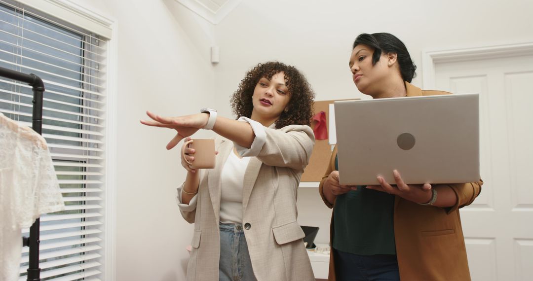 Multiracial Fashion Team Reviewing Lace Sample in Bright Studio with Laptop and Mug