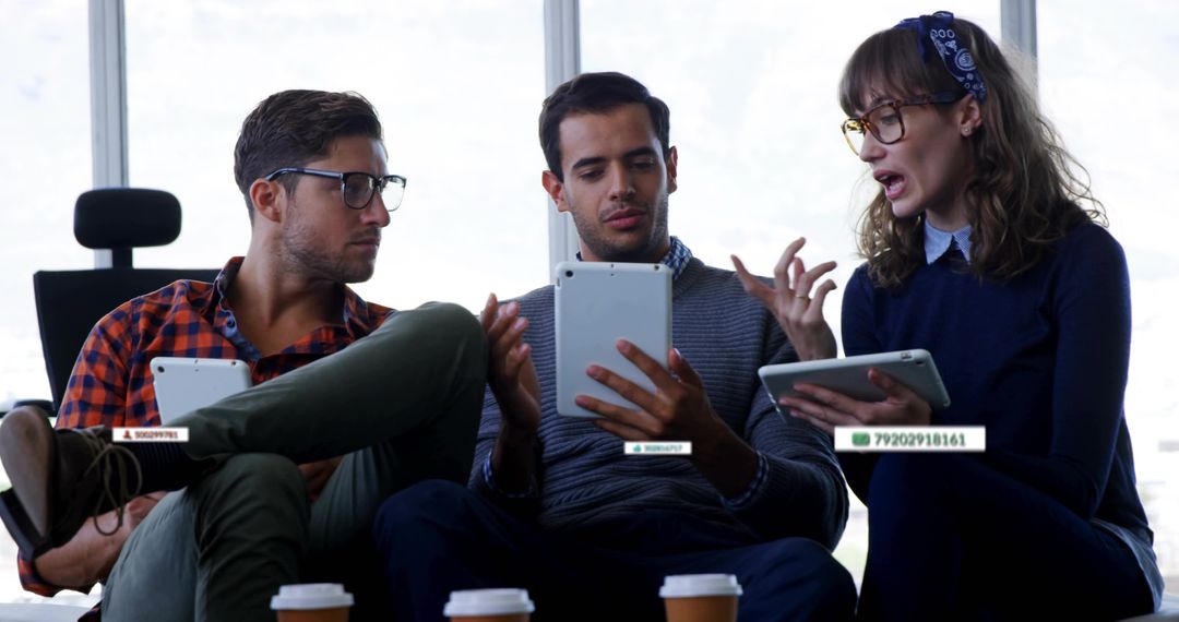 Young Coworkers Collaborating with Tablets and Coffee in Modern Office