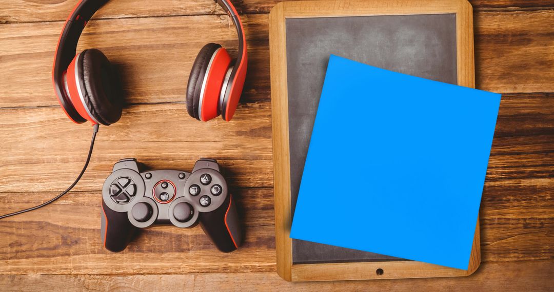 Gaming Headphones and Controller on Wooden Desk with Note