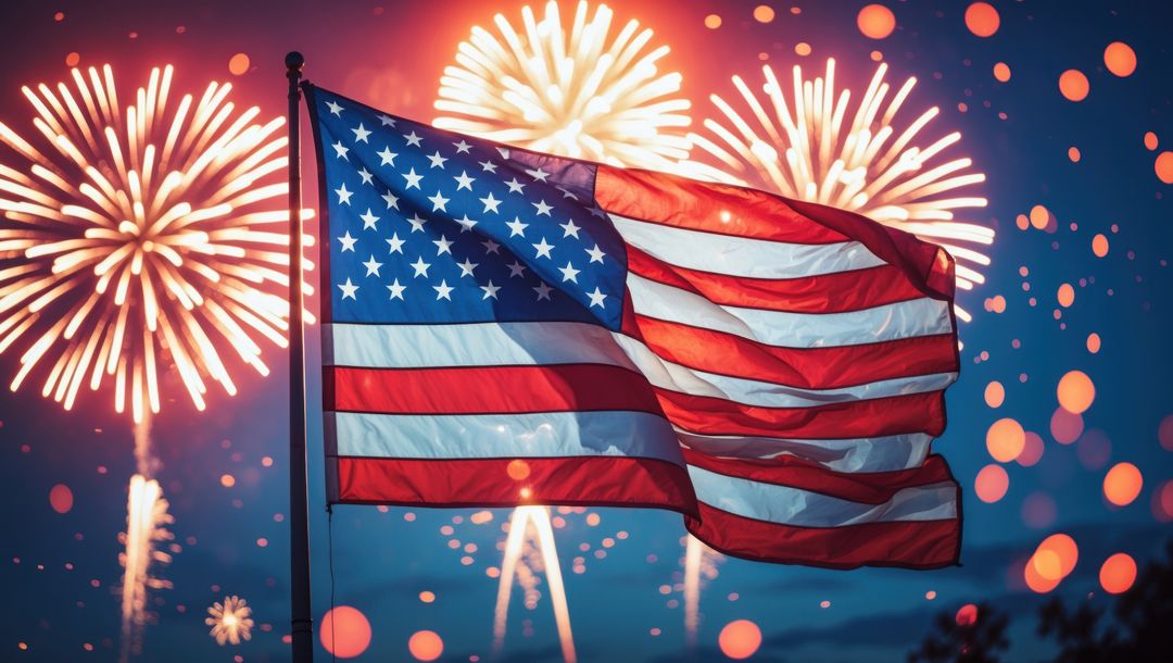American Flag Waving at Night with Bright Fireworks Display