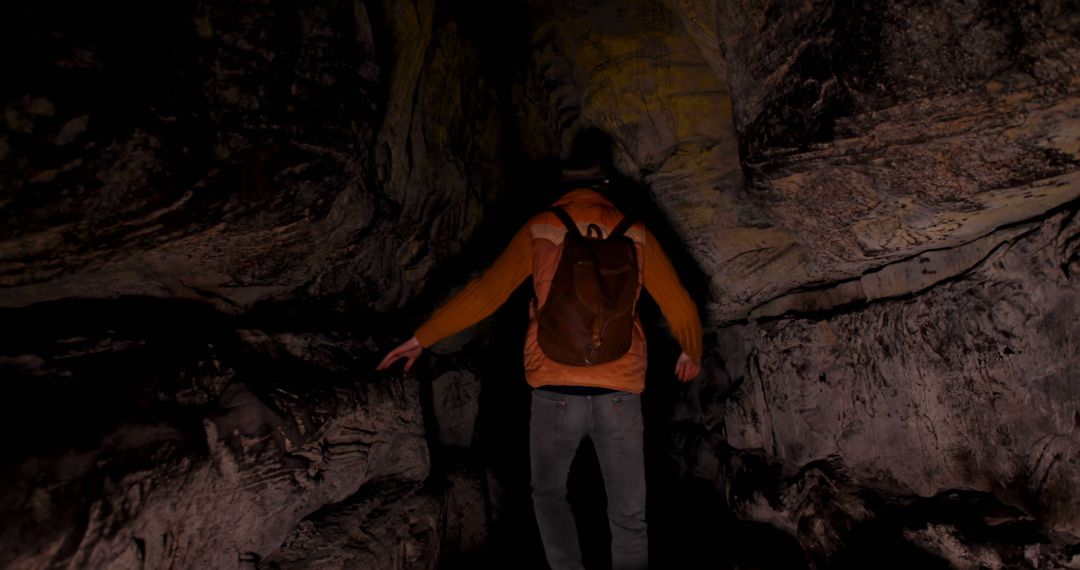 Adventurous Man Exploring Dark Natural Cave