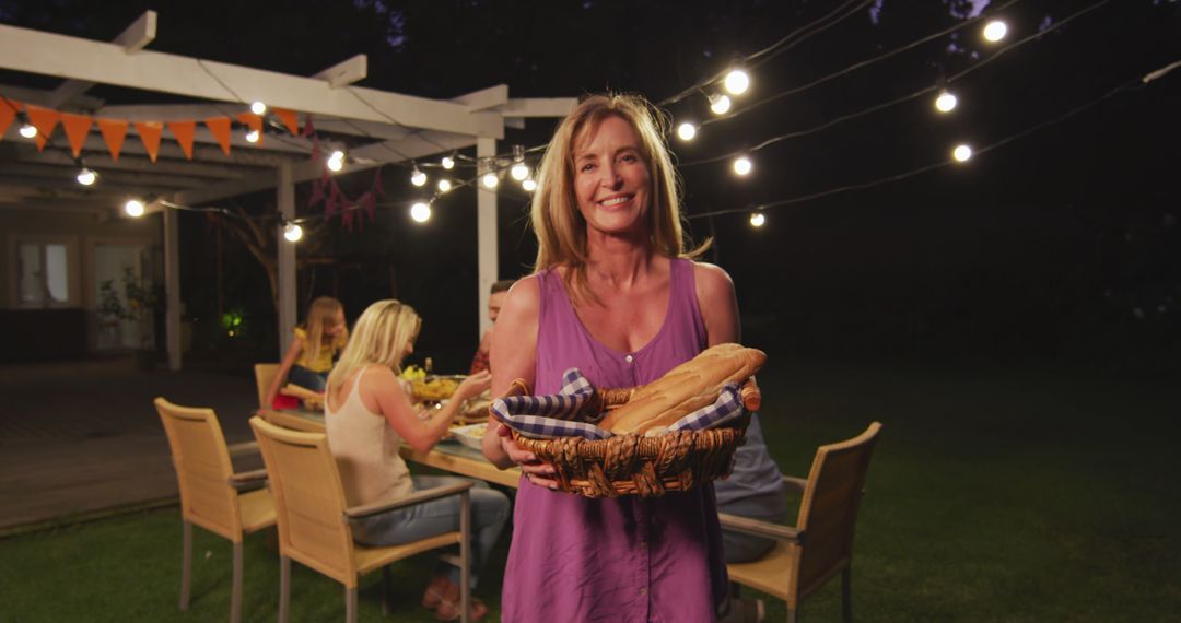 Smiling Woman Hosting Backyard Dinner Party Under String Lights - Free Images, Stock Photos and Pictures on Pikwizard.com