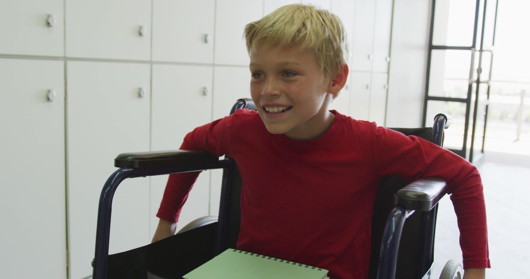 Smiling Boy in Wheelchair Holding Notebook Indoor - Free Images, Stock Photos and Pictures on Pikwizard.com