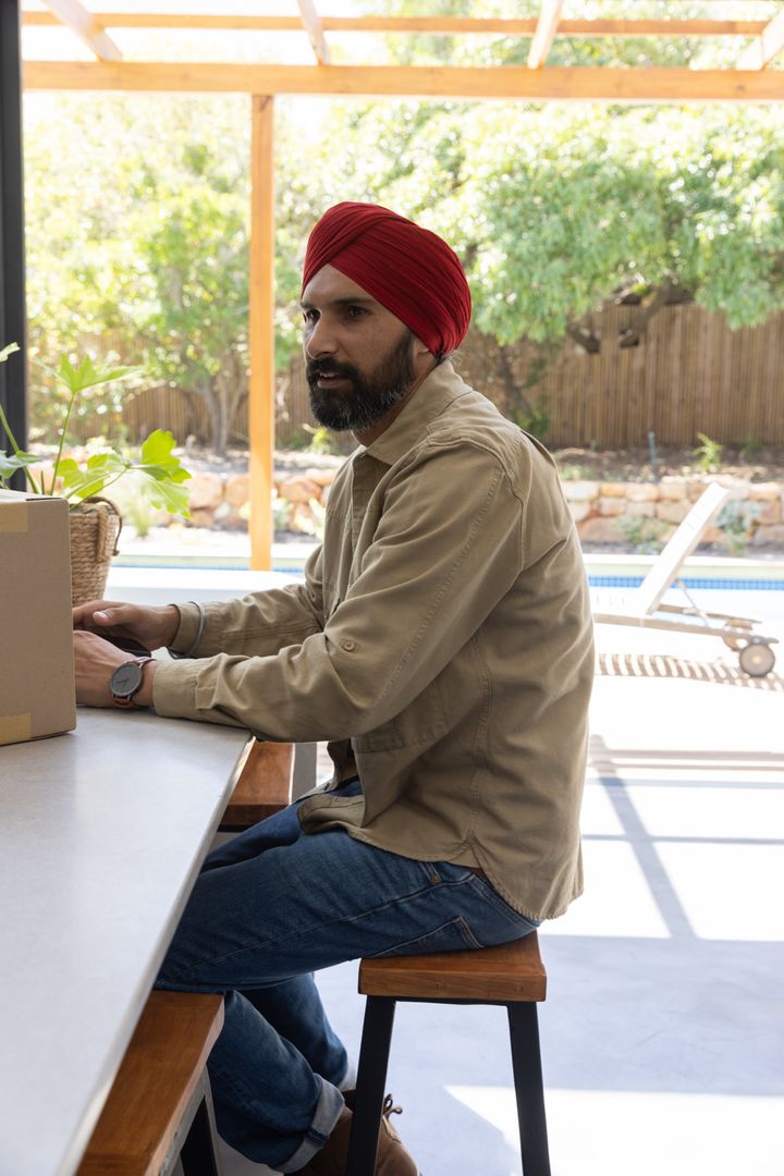 Indian Man with Turban Enjoying Outdoor Workspace Serenity with Box and Planter
