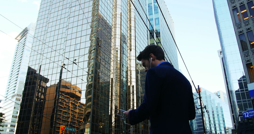 Businessman Listening to Music in Modern Cityscape Background - Free Images, Stock Photos and Pictures on Pikwizard.com