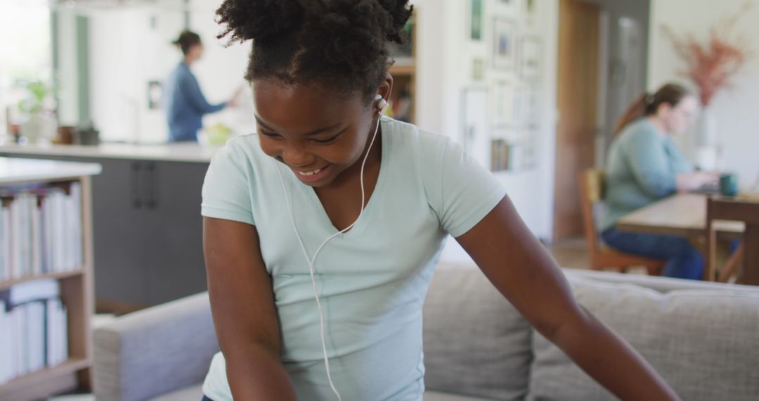 Joyful African American Girl Dancing with Earphones in Modern Living Room