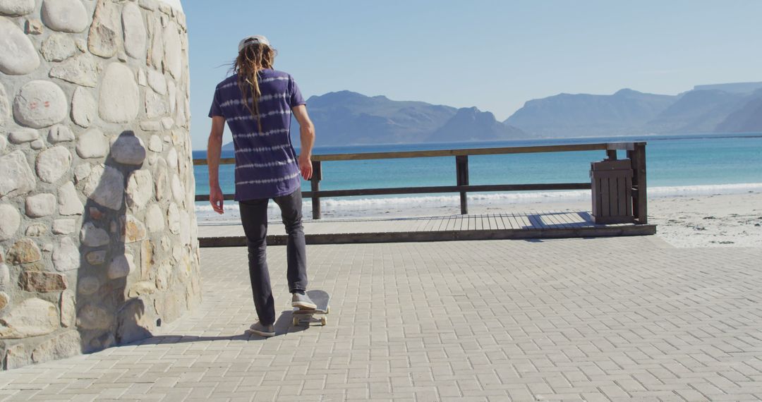 Man with Long Hair Skateboarding by the Seaside - Free Images, Stock Photos and Pictures on Pikwizard.com