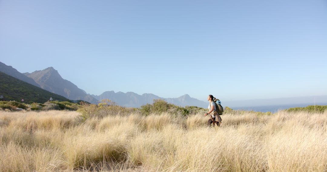 Man Hiking with Backpack in Mountainous Grassland