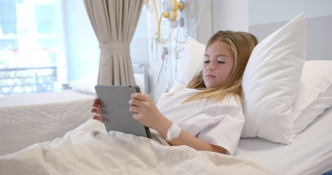 Young girl in hospital bed using tablet - Free Images, Stock Photos and Pictures on Pikwizard.com