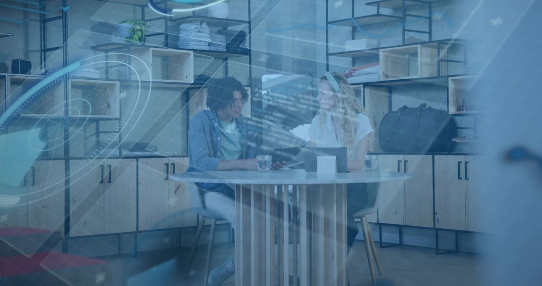 Collaborating over laptop in coworking space with blue digital overlay and teamwork focus