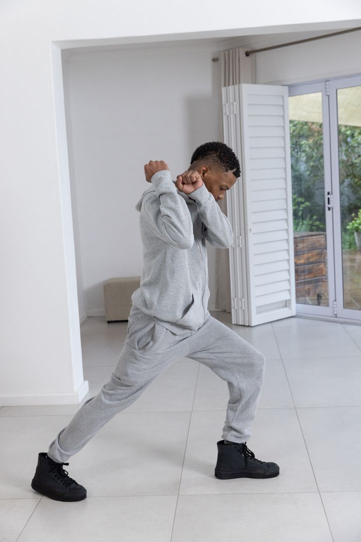 Teen Practicing Forward Lunge Stretch in Minimalist Home