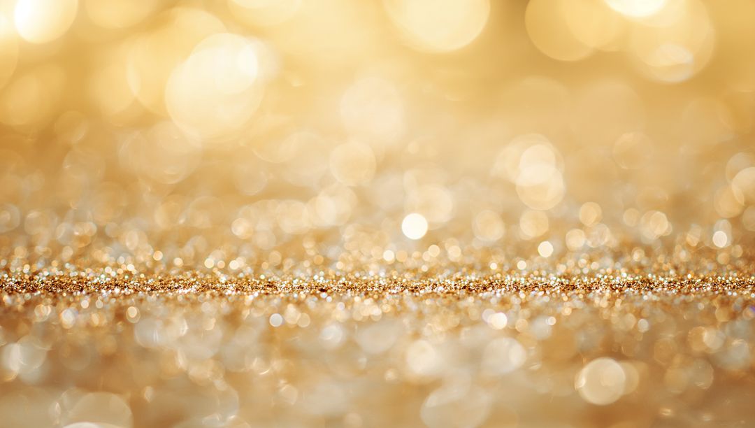 Shimmering golden glitter strip with bokeh sparkle and reflective metallic texture