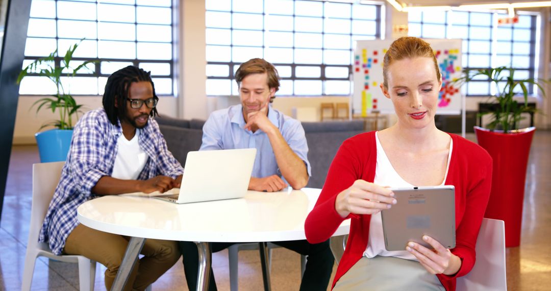 Professional Team Collaborating on Digital Devices in Modern Office