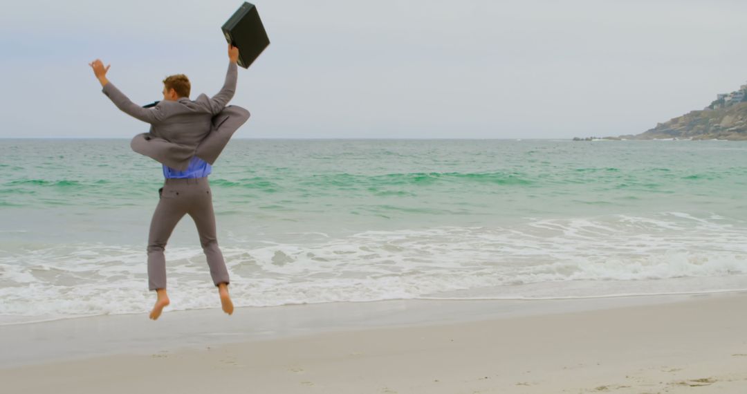 Excited Businessman Jumping for Joy by the Ocean