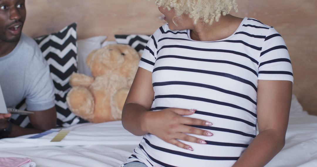 Expecting Couple Shopping Online for Baby Clothes at Home