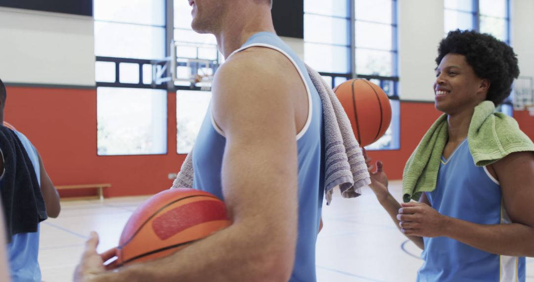 Basketball Players Smiling and Conversing During Practice - Free Images, Stock Photos and Pictures on Pikwizard.com