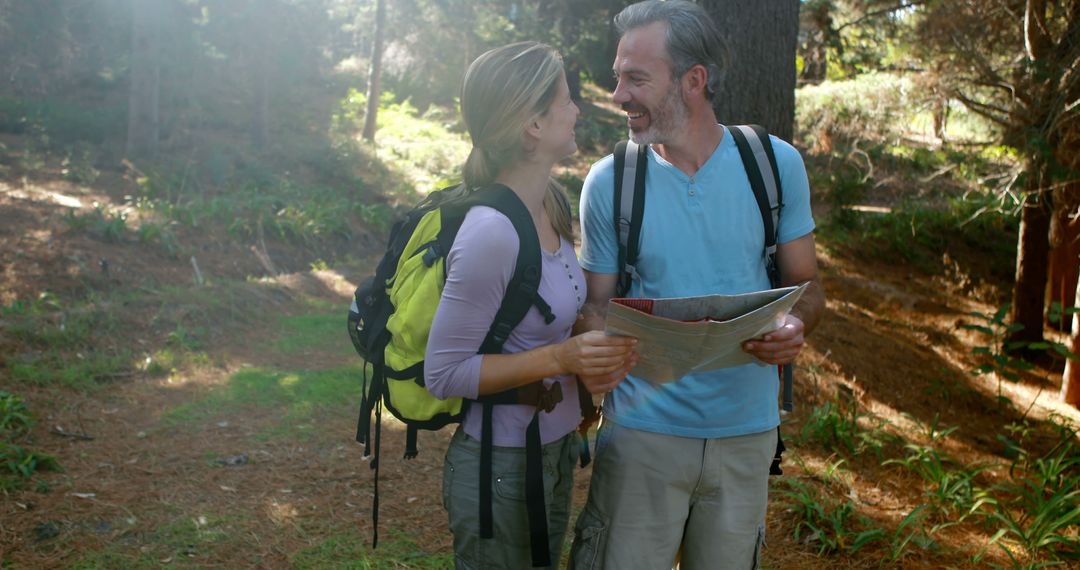 Smiling Couple Hiking in Sunny Forest with Map - Free Images, Stock Photos and Pictures on Pikwizard.com