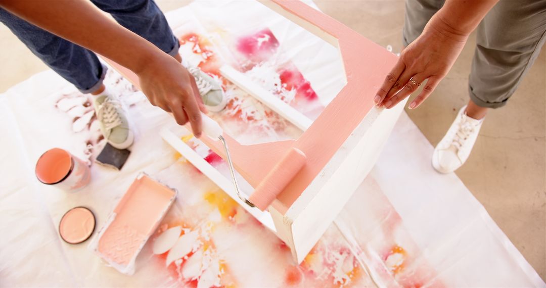 Hands Revamping Furniture with Pink Paint in DIY Project