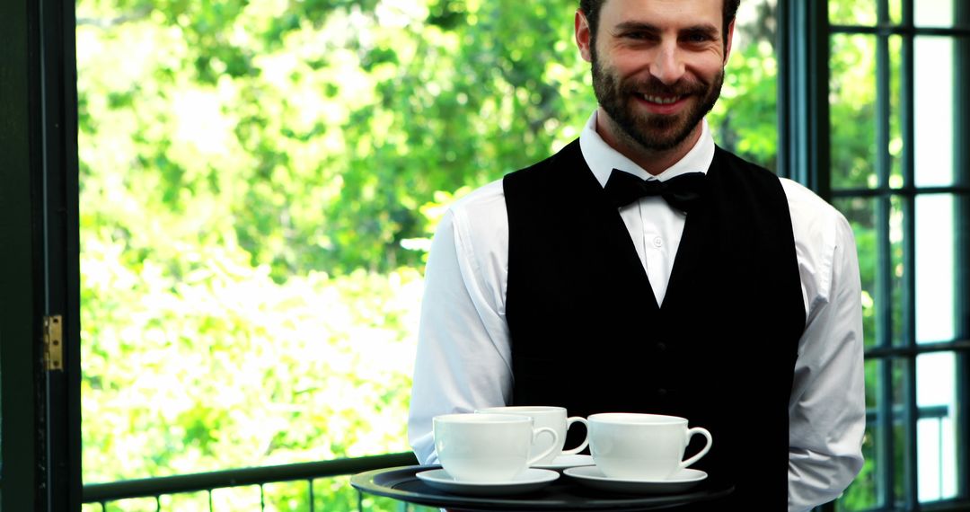 Smiling Waiter with Serving Tray Holding Coffee Cups in Outdoor Cafe - Free Images, Stock Photos and Pictures on Pikwizard.com