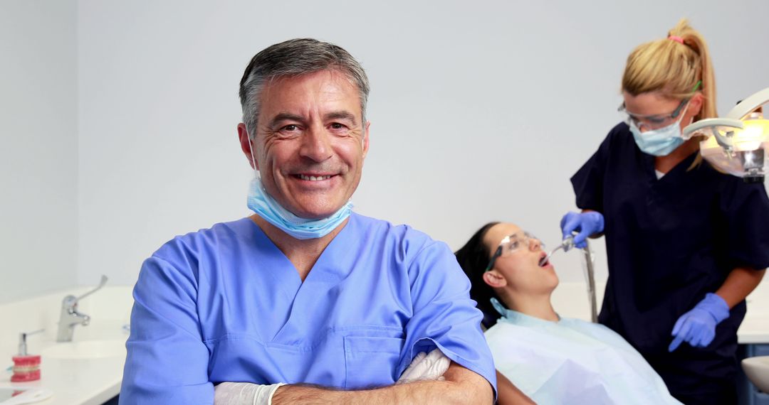 Confident Male Dentist with Assistant Treating Female Patient in Dental Office - Free Images, Stock Photos and Pictures on Pikwizard.com