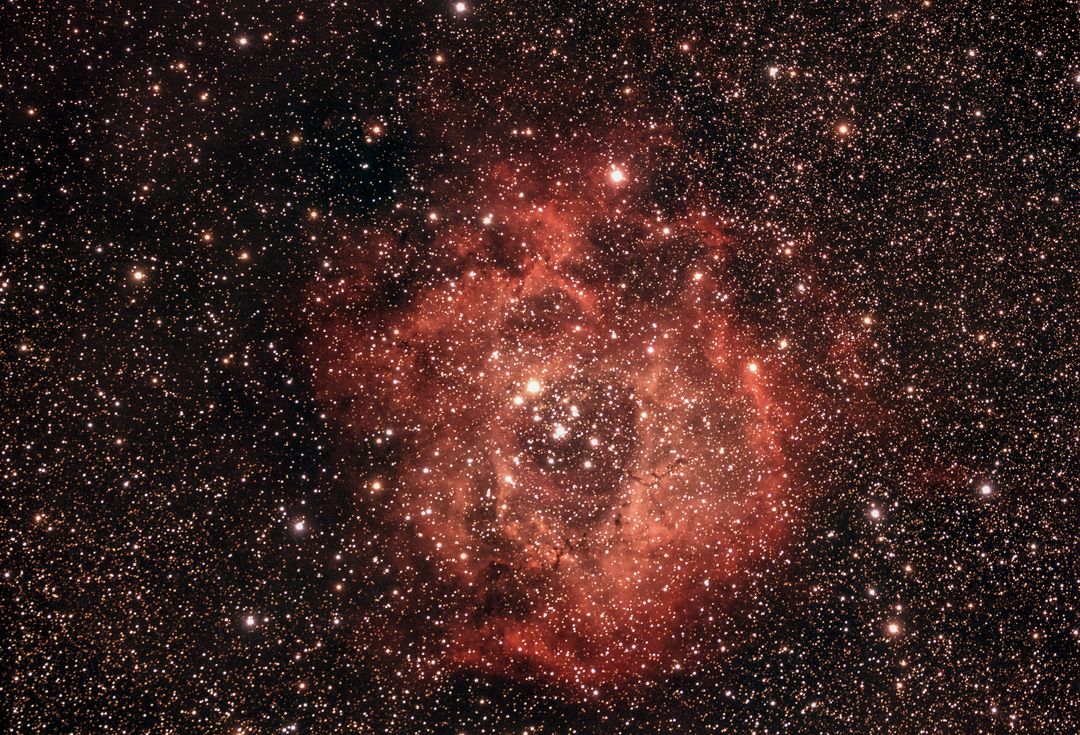 Spectacular red nebula illuminated by universe starry sky